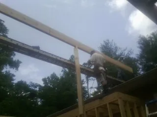 Carpenter setting a ridge beam over a new addition frame — Ice Dam Removal by Roofing Brothers in Saint Paul Park