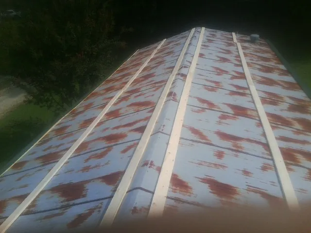 Rusted metal roof panels with new wood purlins before replacement — Storm Damage Roof Repair in Saint Paul Park by Roofing Brothers