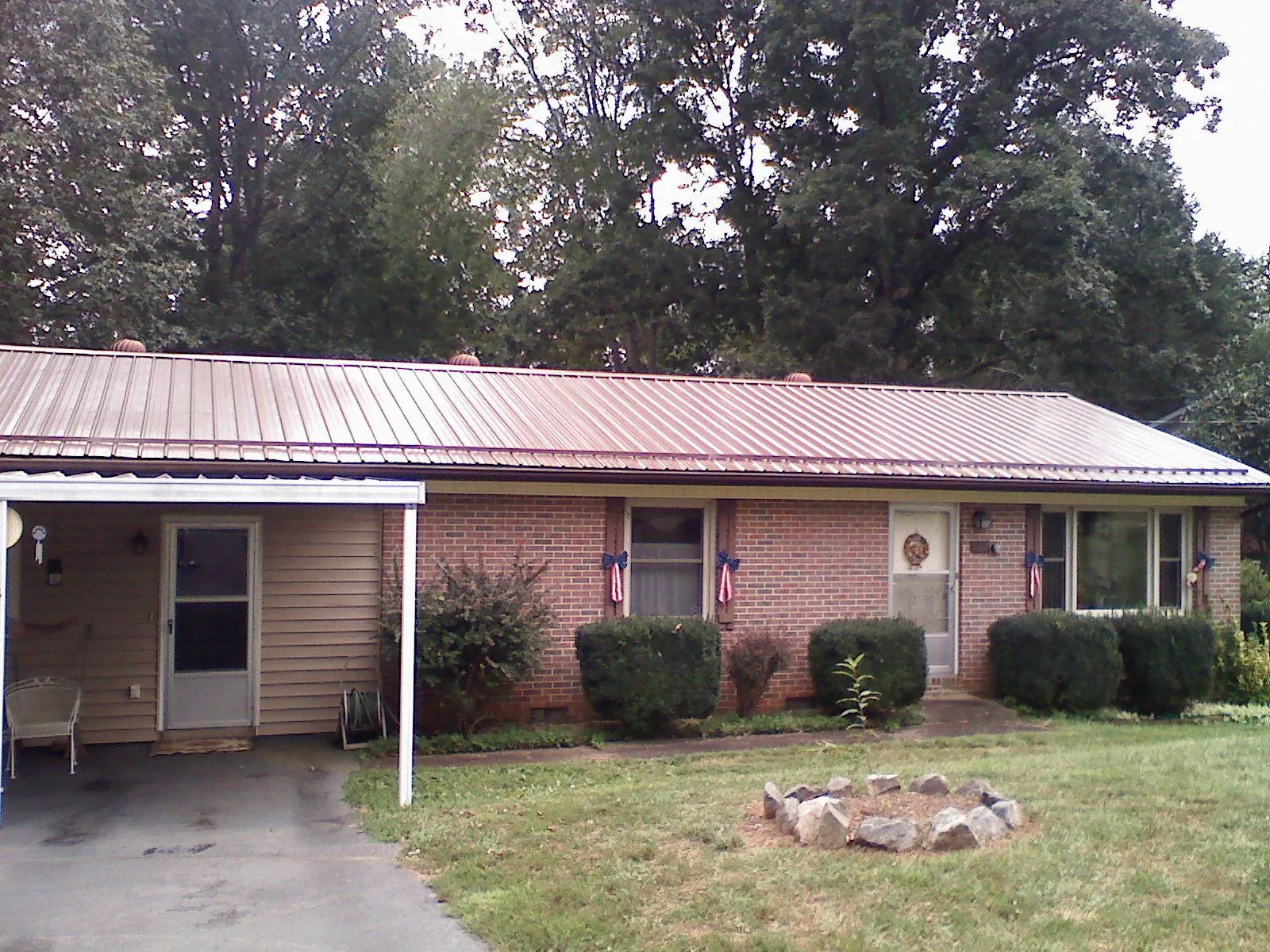 Bronze metal roof and carport on a brick ranch home — Roof Repair work by our crew in Saint Paul Park
